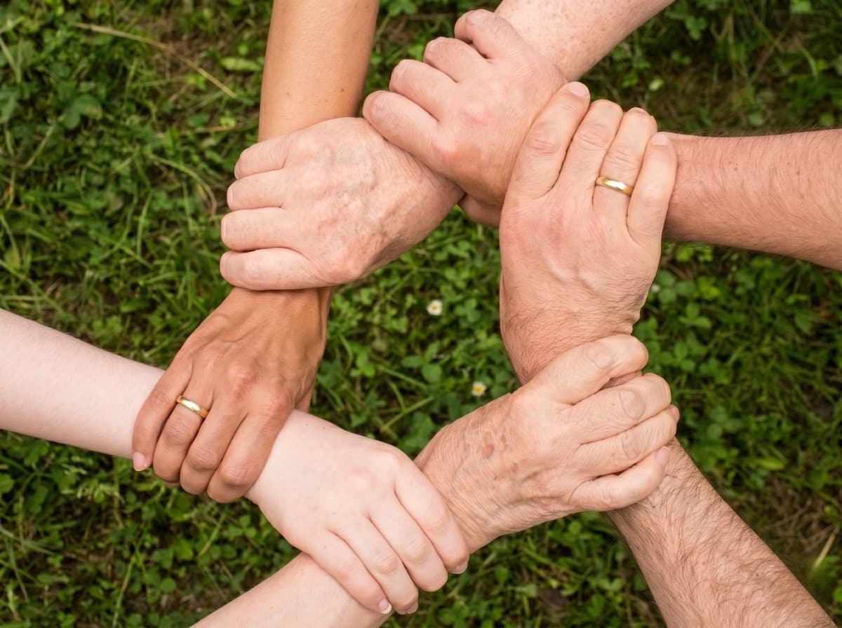 Zusammenhalt – Hände greifen ineinander